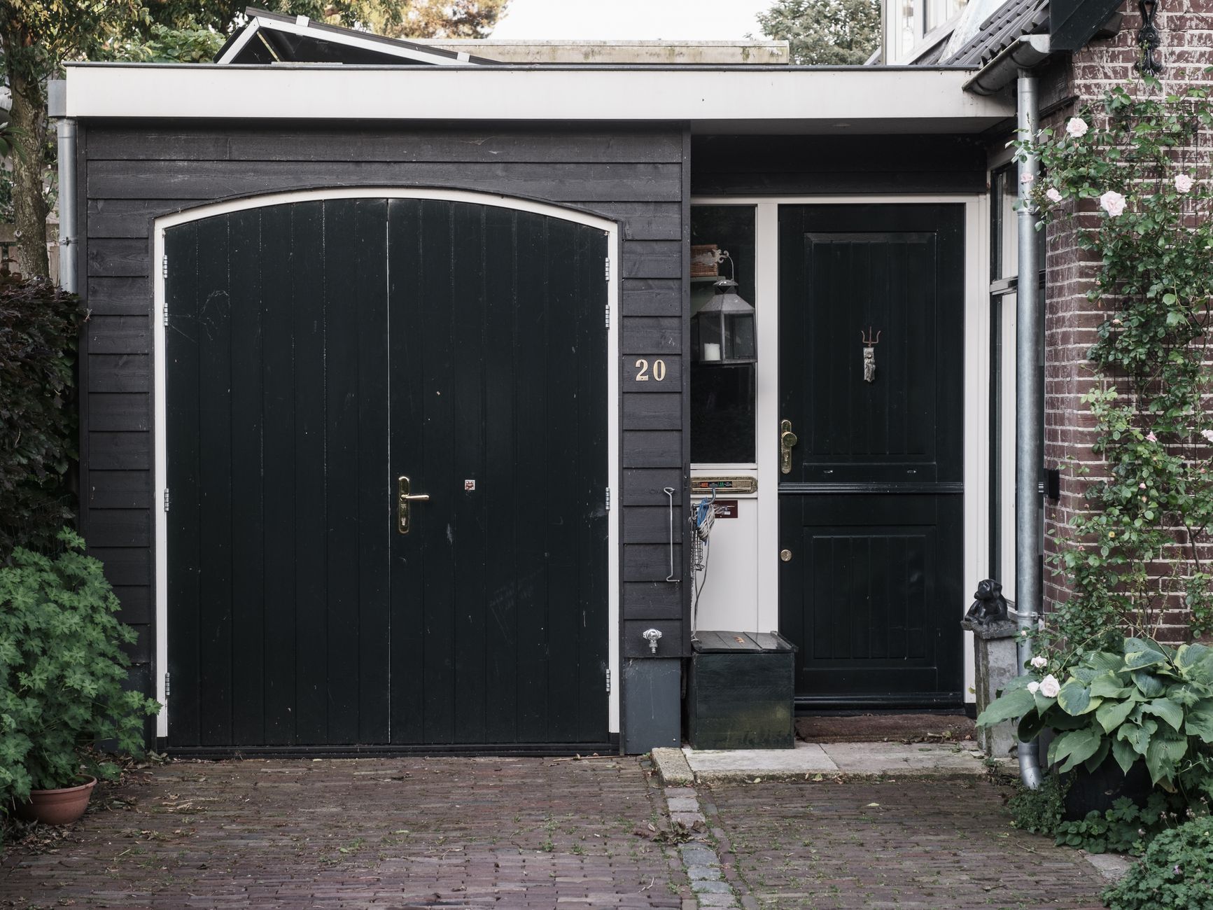 Portable generator running on a driveway outside a garage in daylight