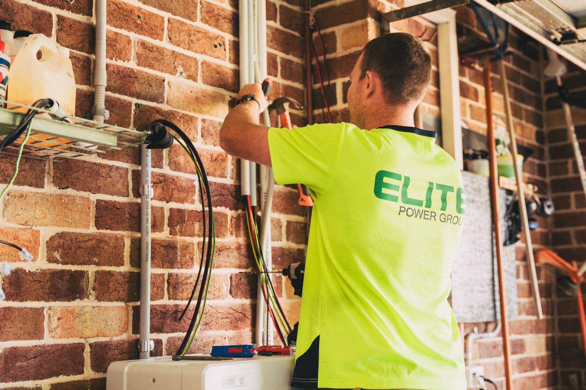 a wall-mounted home battery backup system installed beside an electrical panel in a residential garage