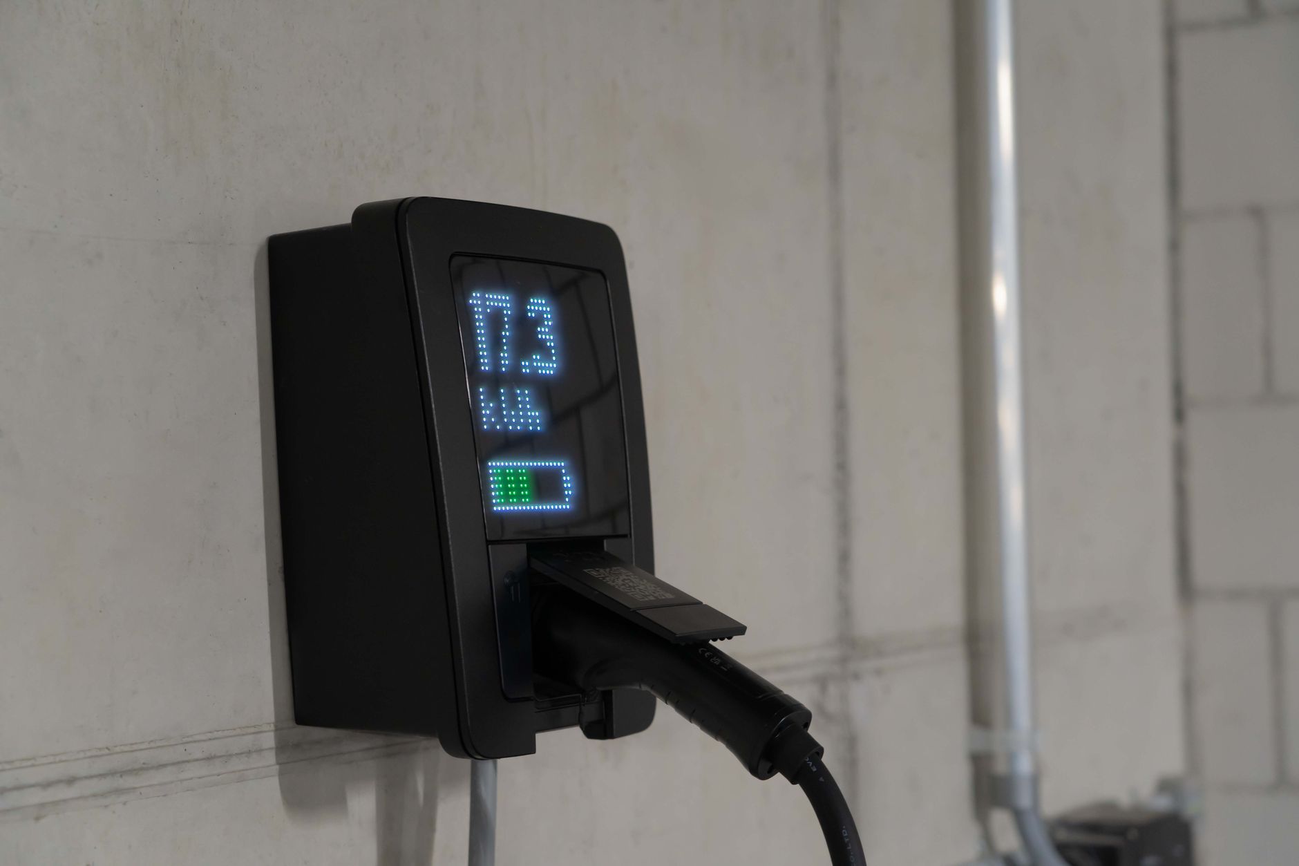 White Tesla Powerwall battery mounted on a residential garage wall